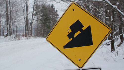 Sign warning of steep hill. Snowy day. Coldwater, Ontario, Canada. HD video.