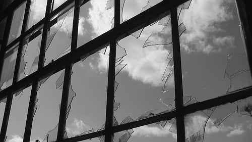 Broken window with shards of glass. Black and white time lapse clouds. HD video.