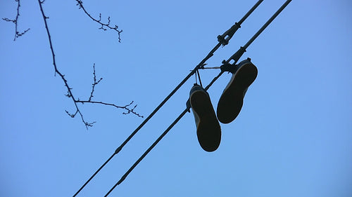 Sneakers hanging from wire. HD video.