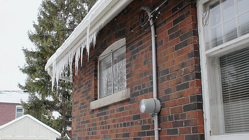 Winter house. Detail. Snow falls and icicles hang. Winter in Toronto, Ontario, Canada. HD video.