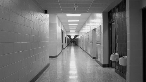 High school hallway with doors at end. Zoom in. Toronto, Ontario, Canada. Black and white. HD video.
