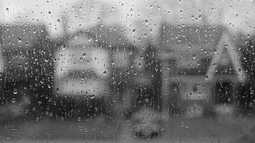 Rain on suburban window. Defocused houses. HD video.