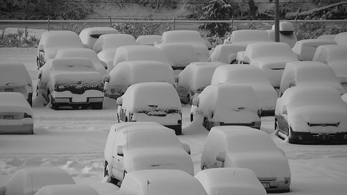 Snowstorm parking lot. Closeup. Truck drives around snowy parking lot. Black and white. HD video.