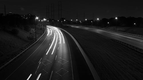 Don Valley Parkway time lapse at night, Toronto. Corner with streaking lights. Black & white. HD.