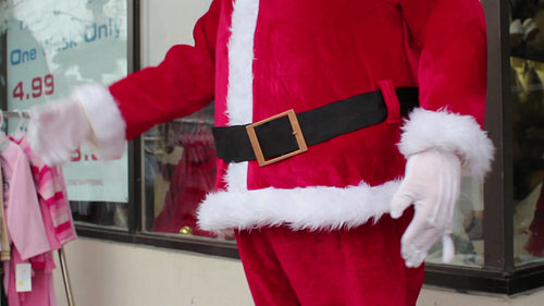 Freaky robot santa dances outside store. Detail of belt, arms and belly. Side view. Toronto. HD video.