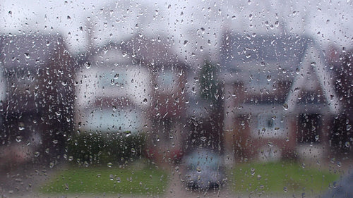 Rain on suburban window. Defocused houses. Black and white. HD video.