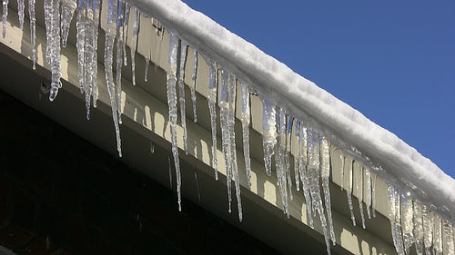Frozen eavestrough with icicles. HD video.
