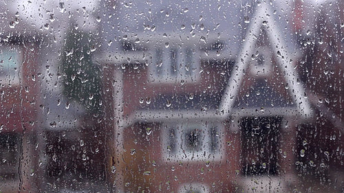 Rain on suburban window. Defocused house. HD video.