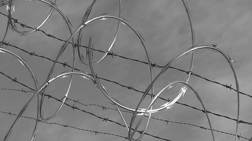 Razor wire. Light cloud time lapse. Black and white. HD video.