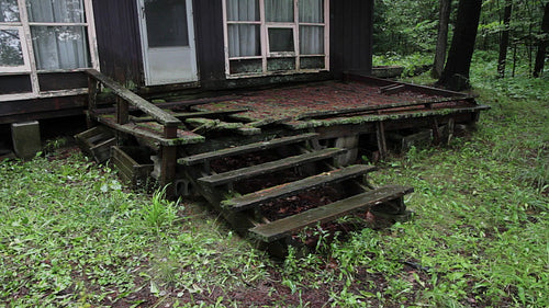 Old wrecked wooden front deck or porch at abandoned cottaage. HD video.