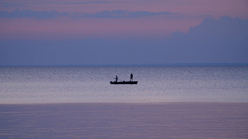 Silhouette of men fishing at sunset. Lake Nipissing, Ontario, Canada. 4K.