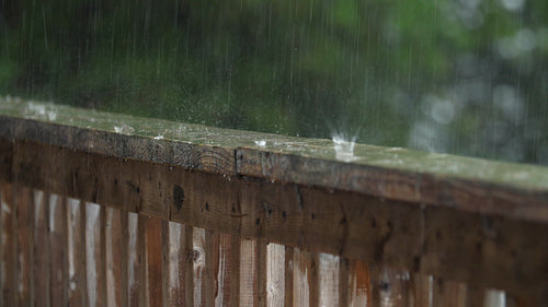 Summer rain falling on wood handrail. Half-speed 4K Clip. Ontario, Canada. 4K.