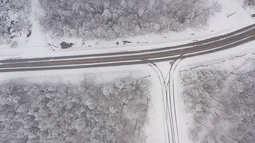 Drone following path of rural winter road. Flying in a snowstorm. Ontario, Canada. 4K.
