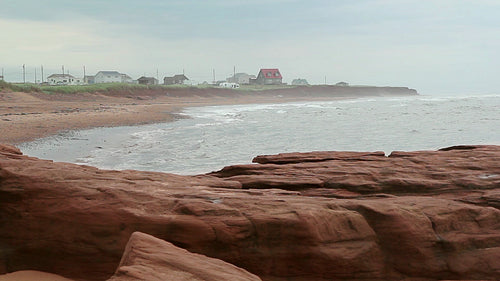 Misty beach with red rocks. Prince Edward Island. HD.