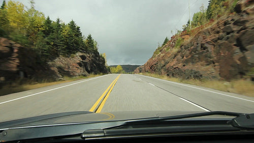 POV driving through rock cut. Trees changing colours. Northern Ontario. HD.