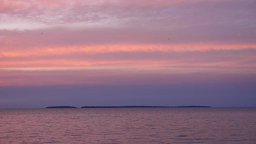 Pink & blue sunset on Lake Nipissing, Ontario, Canada. Manitou Islands in distance. 4K.