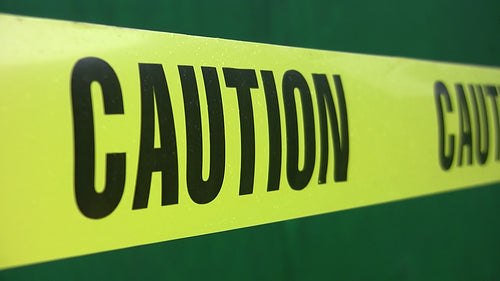 Yellow caution tape with green background. Shallow depth of field. HD video.