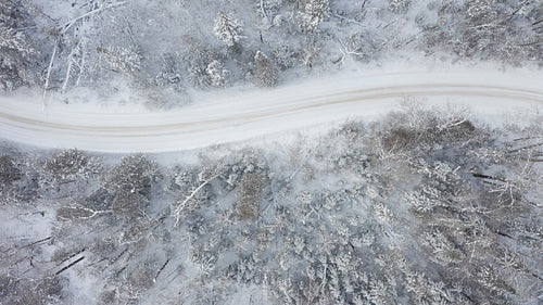Drone flying above curving winter road. 4K.