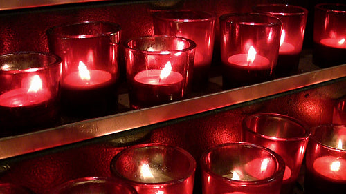 Red church candles on gold shelves. HDV footage. HD.