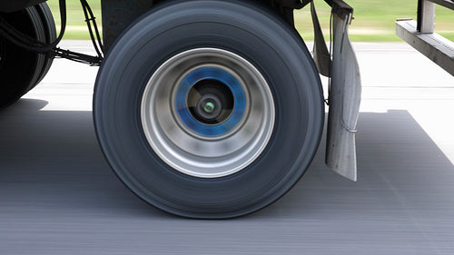 Passing commercial truck or lorry. Detail of wheels with blue hubs. 4K.