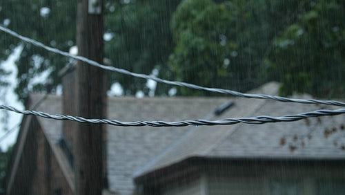 Rain falling on hydro electric wires in suburban neighborhood. Toronto. 4K.