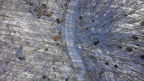 Mellow drone flight over snow covered winter road. Rural Ontario, Canada. 4K.