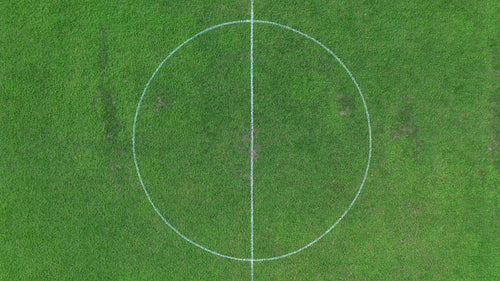 Aerial drone shot rising above football soccer field revealing whole pitch. 4K.