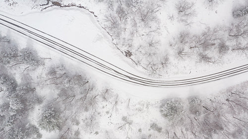 Drone following path of rural winter driveway. Snow falling. Ontario, Canada. 4K.