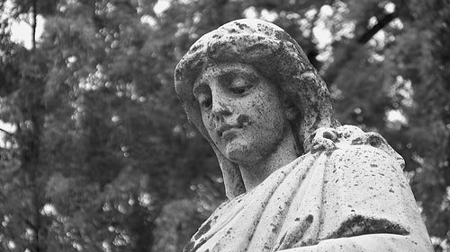 Grieving cemetery statue. Portrait, with detail of face. Black & white. HD video.