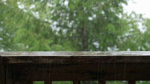 Summer rain falling on wood handrail. Half-speed 4K Clip. Ontario, Canada. 4K.