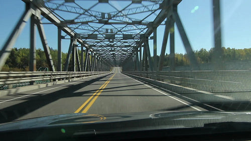 Driving across a long truss bridge. Northern Ontario, Canada. Flickering sun. HD.