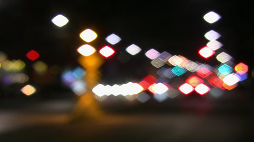 Pretty city lights. Defocused lights at downtown intersection. HD video.