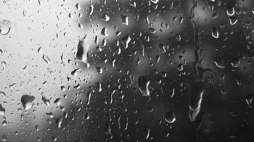 Rain drops on window during summer storm. Black and white. HDV footage. HD.