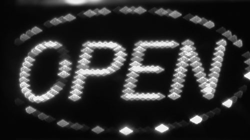Open sign with flashing LED lights. Store advertising. Toronto, Canada. Black & white. HD video.