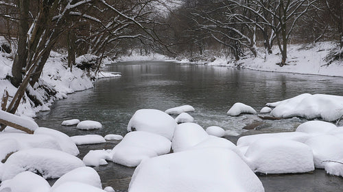 Winter river and snow covered rocks. View downstream. Don River, Toronto. 4K.