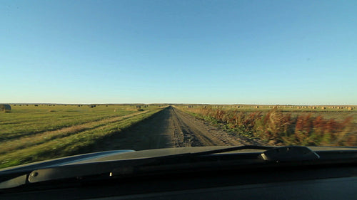 POV driving on farm road with hay bales. Saskatchewan, Canada. HD.
