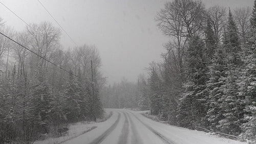 Heavy snow falling on country road. Winter in rural Ontario, Canada. HD.