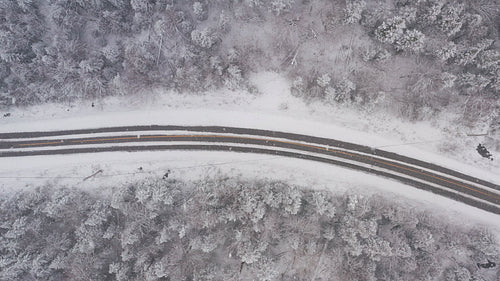 Drone following path of rural winter road. Flying in a snowstorm. Ontario, Canada. 4K.