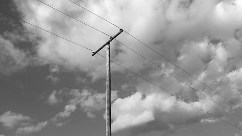 Utility telephone pole with clouds. Light time lapse. Black and white. HD.