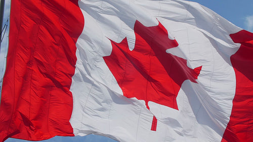 Slow motion closeup of large Canadian flag blowing in the wind. HD.