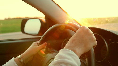 Sunset drive. Detail of woman driving car at sunset. HD.