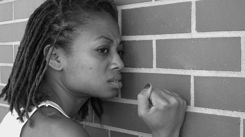 Frustration. Frustrated girl bangs her fist against wall. Black and white. HD video.