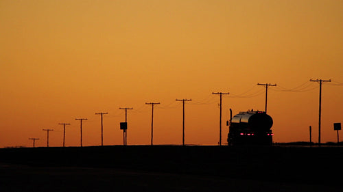 Truck at dusk with orange sky and telephone poles. Saskatchewan, Canada. HD.