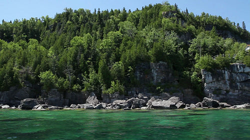 Passing the cliffs and trees of Flowerpot Island in Tobermory, Ontario, Canada. HD.
