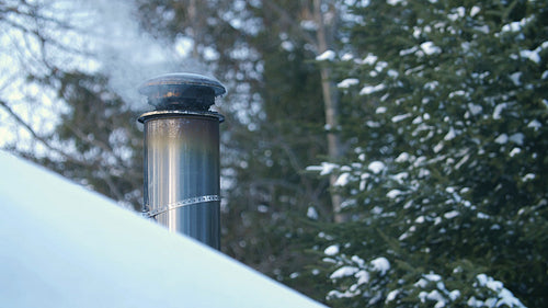Winter chimney with wood smoke and snowy roof. Rural Ontario, Canada. 4K.