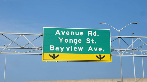 Slo mo Toronto road sign on Hwy 401. Avenue Rd. Yonge St. Bayview Ave. HD.