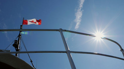Slow motion view of Canadian flag and sunshine. Toronto islands ferrry. HD stock video.