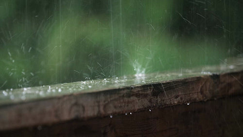 Summer rain falling on wood handrail. Half-speed 4K clip. Ontario, Canada. 4K.