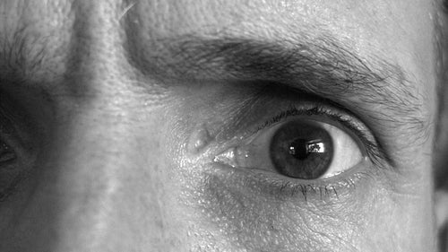 Paranoid eye looking right, left, up, down and then straight at camera. Black and white. HD.