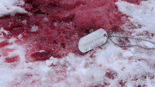 Military ID dogtag in pool of freezing blood. Winter death. Horror. War. HD.